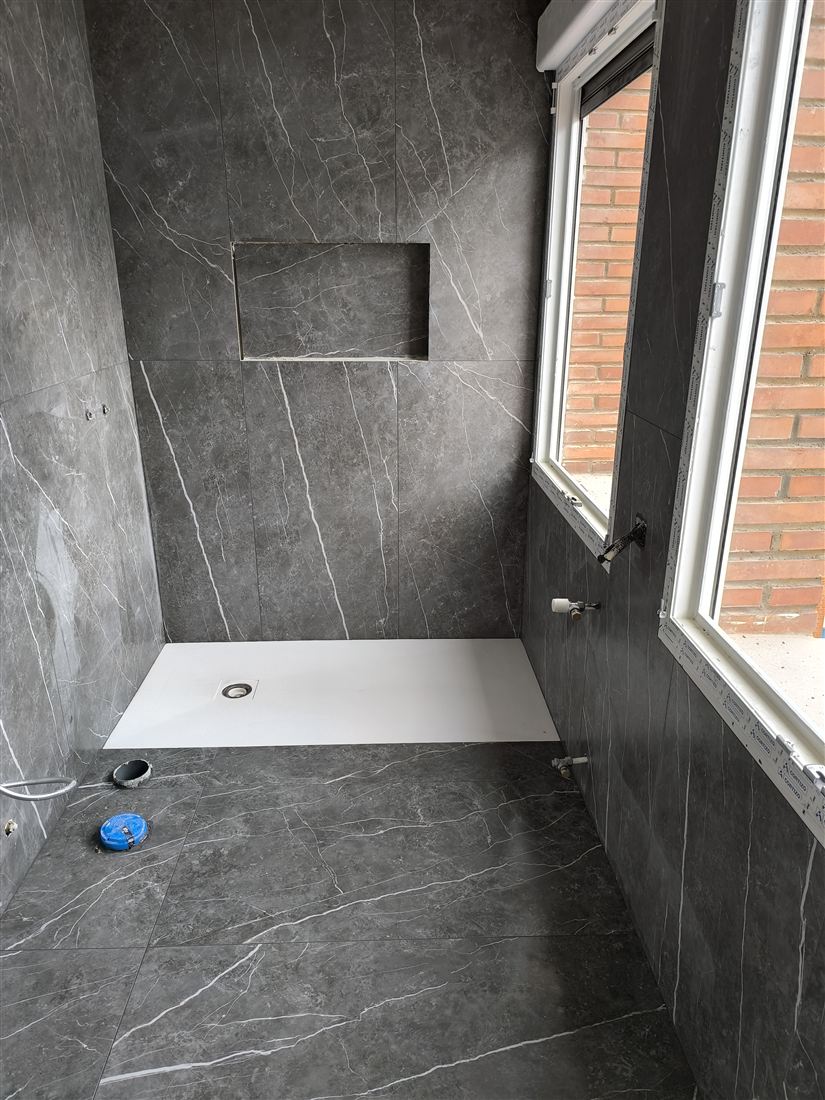 Baño de diseño con revestimiento gris realizado por Solados y Alicatados ReFoMat