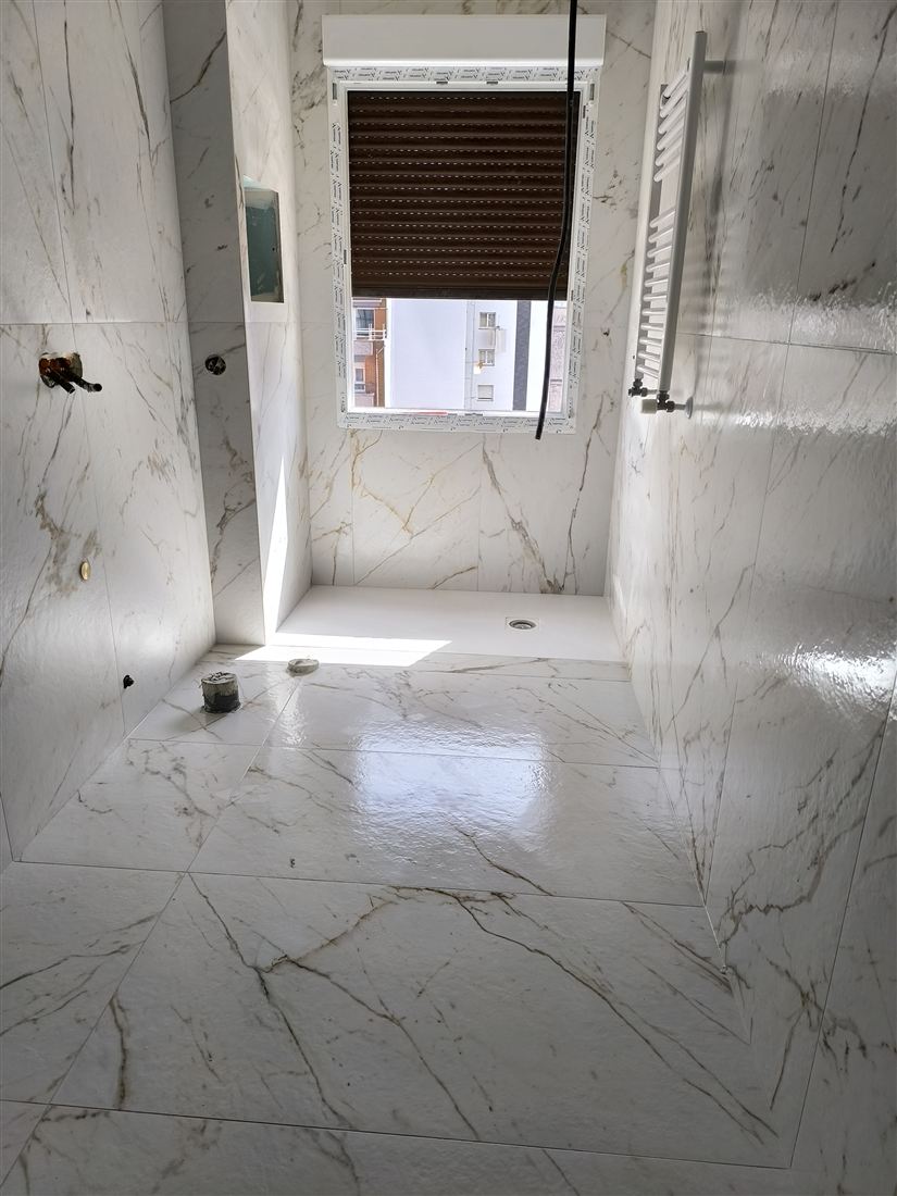 Baño luminoso con acabado claro realizado por Solados y Alicatados ReFoMat
